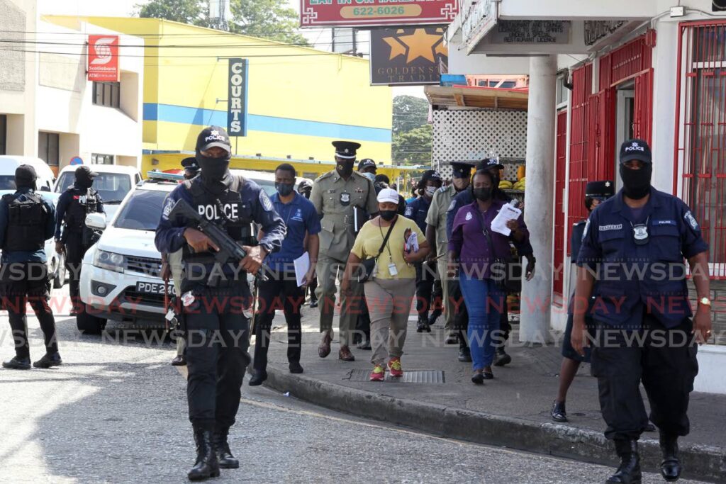 Councillor June Durham and Snr Supt Glen Charles and other police officials, greet members of the St James business community during a Port of Spain City Police anticrime initiative on Friday. - ROGER JACOB
