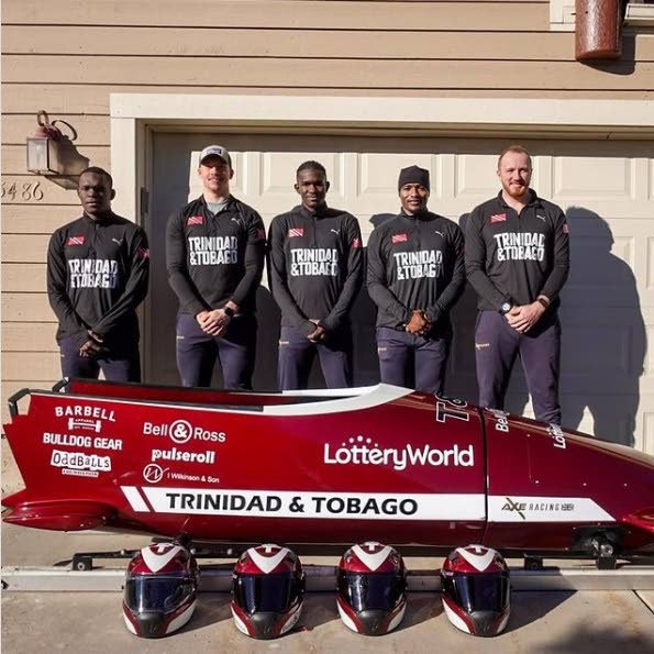 TT bobsled team stand behind their sled. Axel Brown (L-R), Andre Marcano, Shomari John, Tom Harris (coach), Shakeel John. Mikel Thomas, a former TT Summer Olympian, is not in the picture. - TT BOBSLED INSTRAGRAM