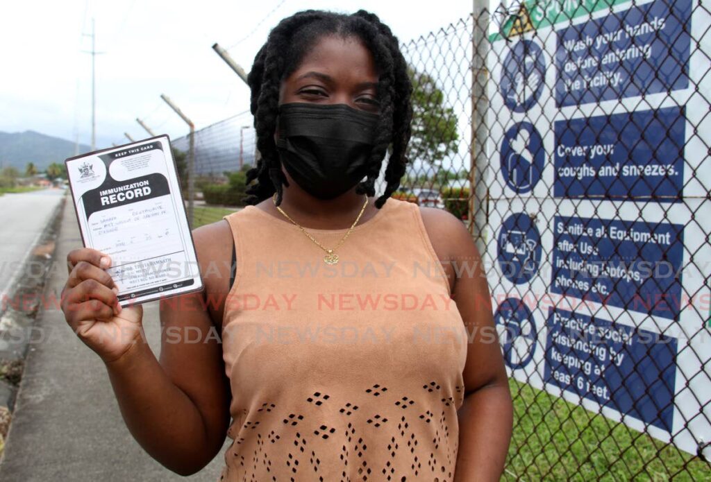 Samara Brathwaite shows her vaccination card after receiving her booster shot at the Larry Gomes Stadium, Malabar. - Photo by Ayanna Kinsale