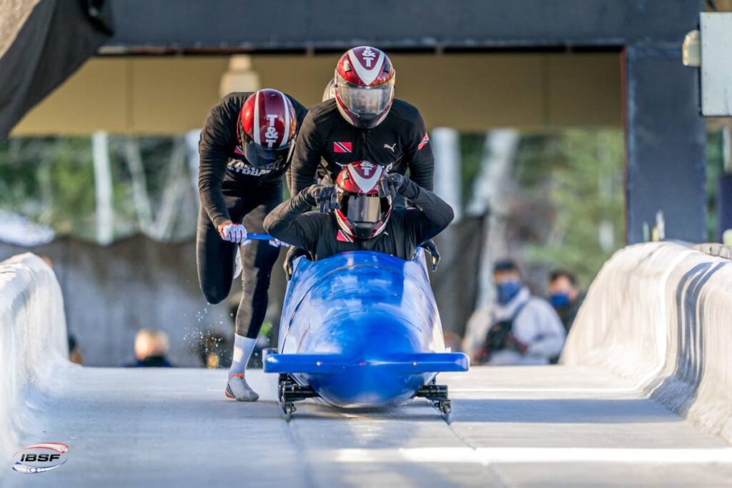 (front to back) Trinidad and Tobago bobsled team members Axel Brown, Shomari John, Tom Harris and Shakeel John (partially hidden) take part in a recent tournament. - Photo courtesy Intl Bobsleigh and Skeleton Federation
