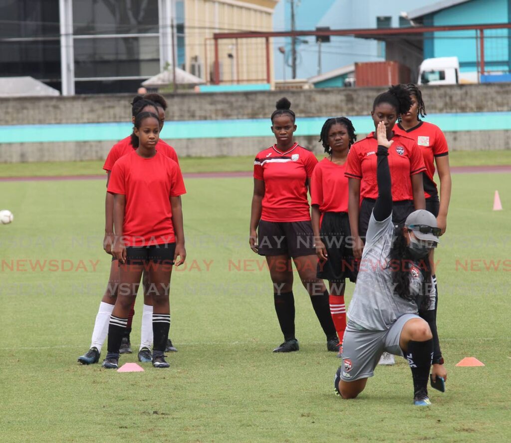 Coach Ashlee Alonzo demonstrates an exercise as she conducts a training session at the TT women’s national under 17 football tryouts at the Manny Ramjohn Stadium, Marabella, on Wednesday. - Lincoln Holder