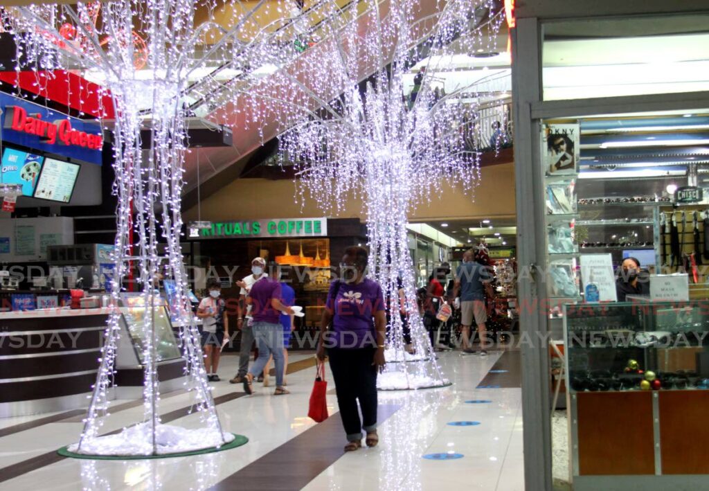 A shopper looks at the Christmas decoration at Long Circular Mall, St James on Wednesday. - Photo by Ayanna Kinsale