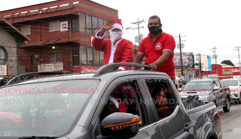 Santa Claus and a volunteer from the Aranguez Taxi Drivers' Association arrive at the Aranguez Taxi Stand, San Juan, to distribute treat bags and toys to children. - Sureash Cholai