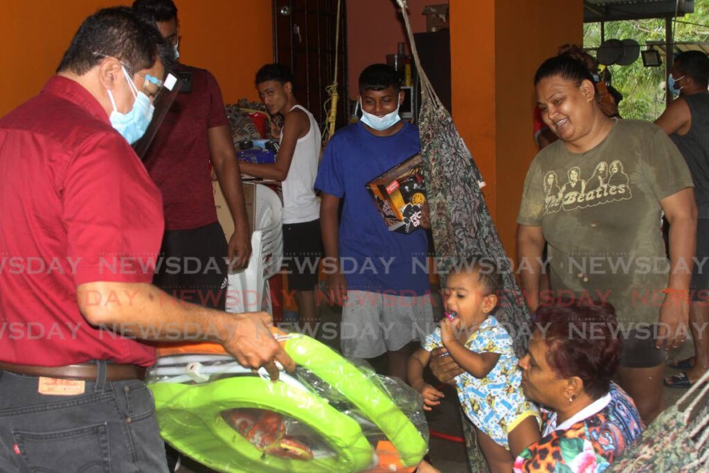 Eleven-month-old Leanna looks on as Fyzabad MP Dr Lackram Bodoe delivers a walker to the Choon family at Ackbar Trace, Fyzabad on Friday.  - Angelo Marcelle