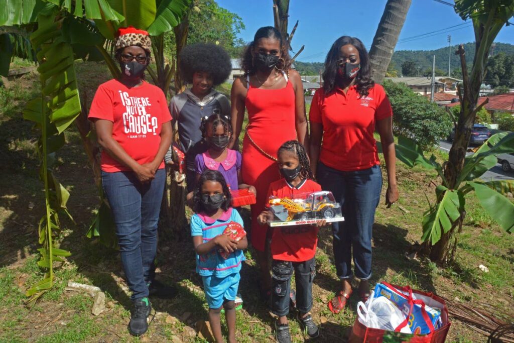 Minister of Social Development and Family Services Donna Cox presents the Amoroso family with toys and a food hamper.  - Photo courtesy Ministry of Social Development and Family Services