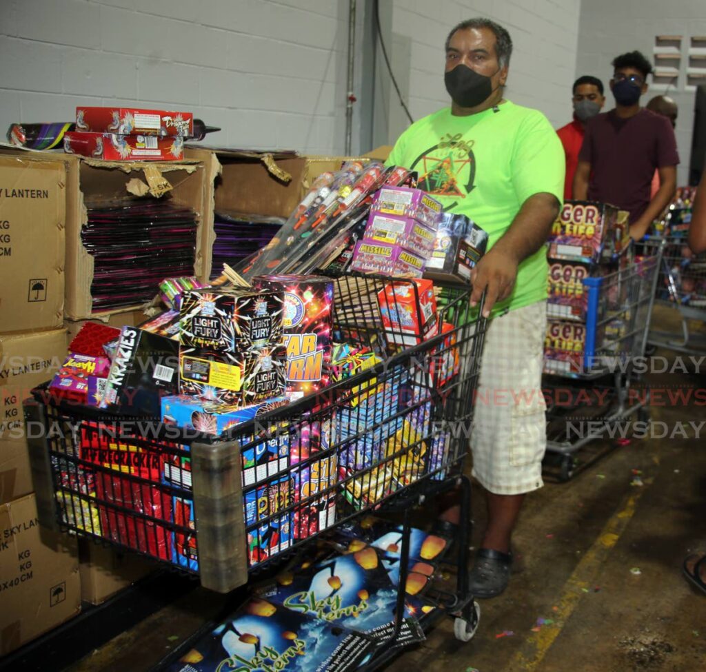 This man with his trolley fully loaded waits in line to pay for his fireworks at the annual Boxing Day sale at FireOne in Macoya on Sunday. - SUREASH CHOLAI
