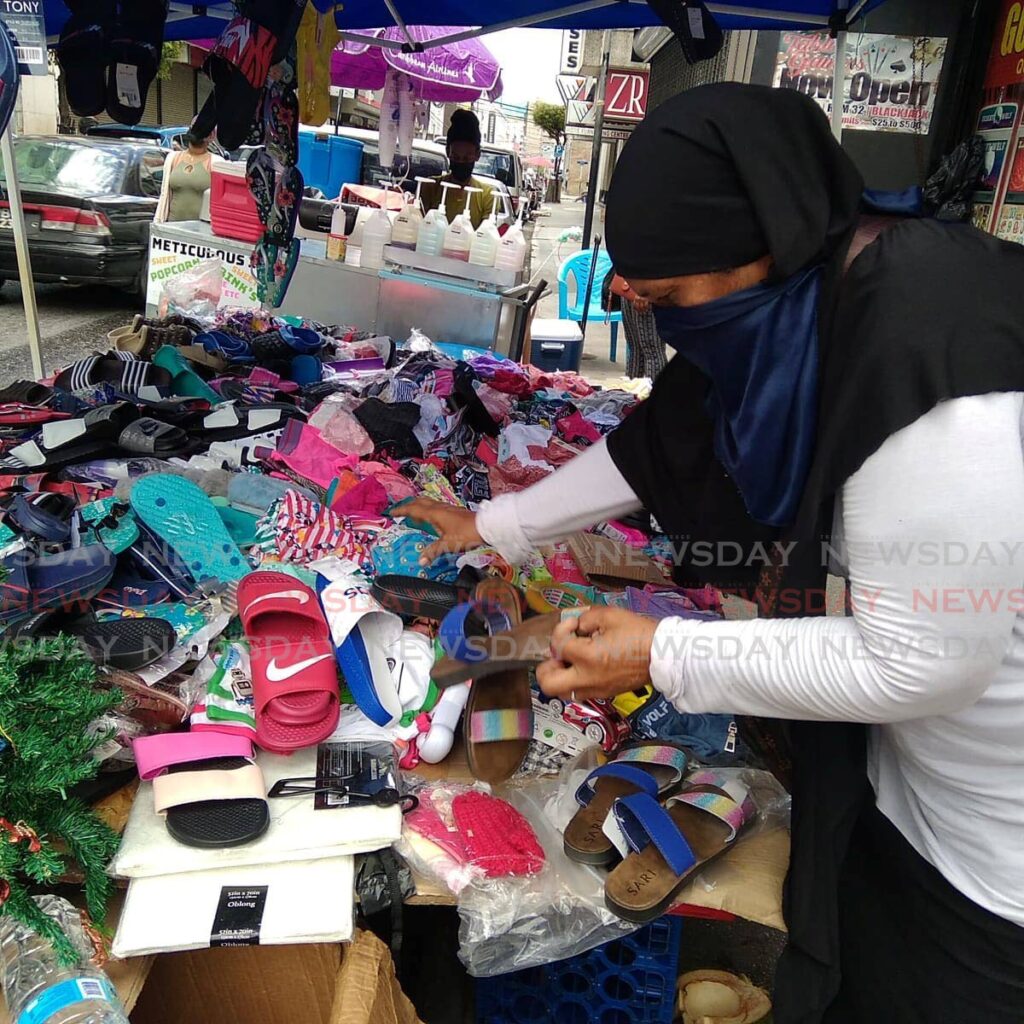 Vendor Franka Rashid organises slippers at her stall at the corner of Queen and Charlotte Streets, Port of Spain on Monday - Shane Superville