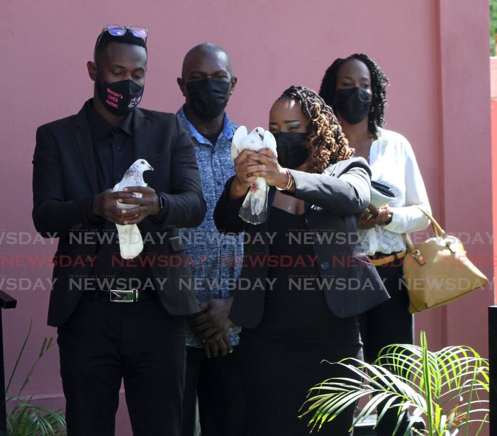 Hyron Brown Baptiste,left,  son of retired Newsday assistant Sports Editor George Baptiste and Paulina Noel get set to release a dove in Baptiste's honour during his funeral held at Dennie's Funeral Home, Lucien Road, Belmont on Tuesday.  - Angelo Marcelle