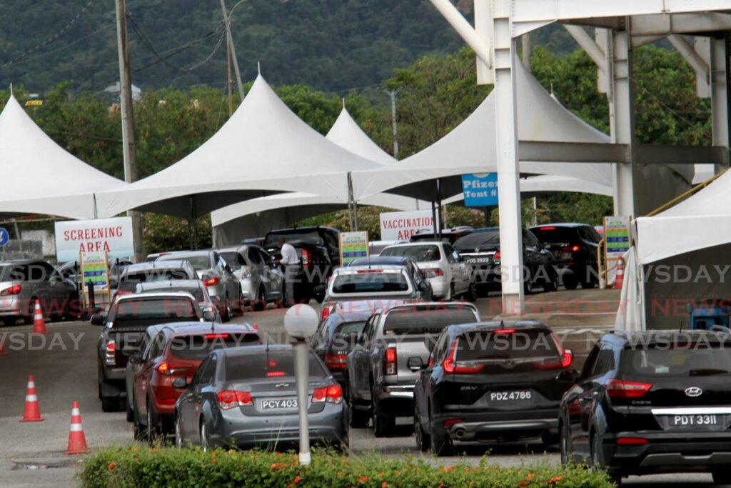 People wait in vehicles to receive covid19 vaccines at Hasley Crawford Stadium, Port of Spain on Tuesday. Government plans to furlough unvaccinated public sector employees from mid-January. - PHOTO BY AYANNA KINSALE