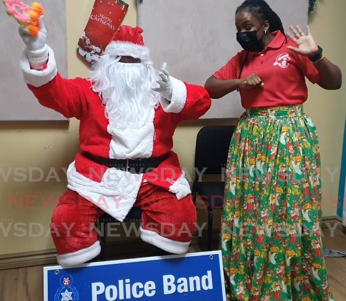 Organiser of the police band's children's Christmas treat WPC Josanne George demonstrates covid19 safety protocols with Santa at the police band's building, Ricerside Plaza, Port of Spain. Photo by Cherisse L Berkeley
