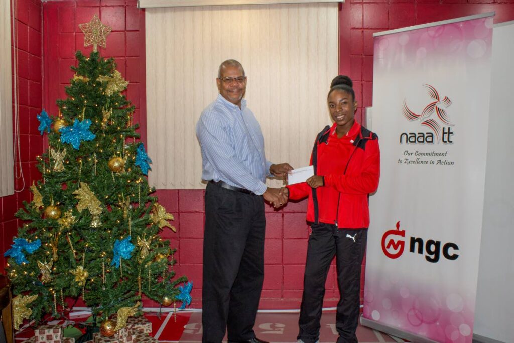 NAAATT president George Commissiong presents 100m sprinter Leah Bertrand with an airline ticket to Ohio. - Courtesy NAAATT