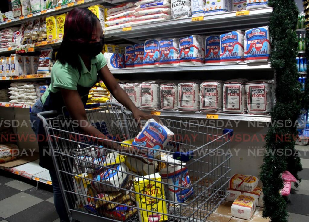 Antoniana Clarke stocks flour at Better Deal Supermarket in Aranguez on Wednesday. - SUREASH CHOLAI