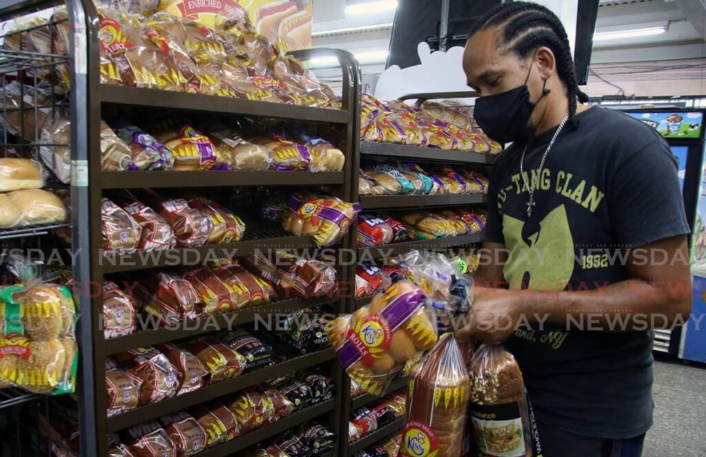 In this file photo, Gerald De Freitas buys from a range of Kiss breads at Benefit The People Supermarket on the Eastern Main Road in San Juan.