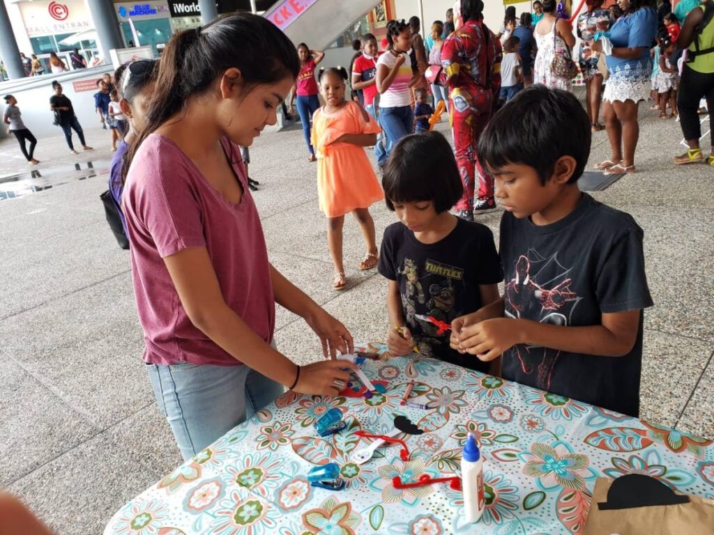 Support Autism TT's volunteer Melanie Kissoon having fun at craft with Evan and Eli Bikharry. Research has shown that doing something good for others increases your own level of wellbeing. Photo courtesy Support Autism TT - 