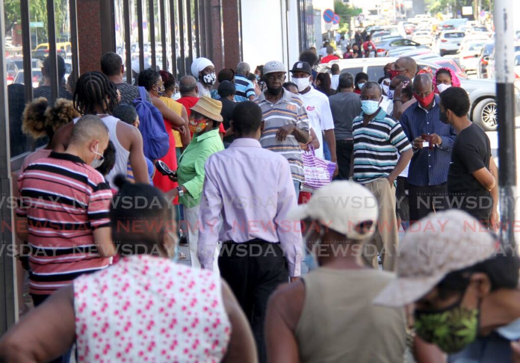 Customers wait outside a bank in Port of Spain. - AYANNA KINSALE