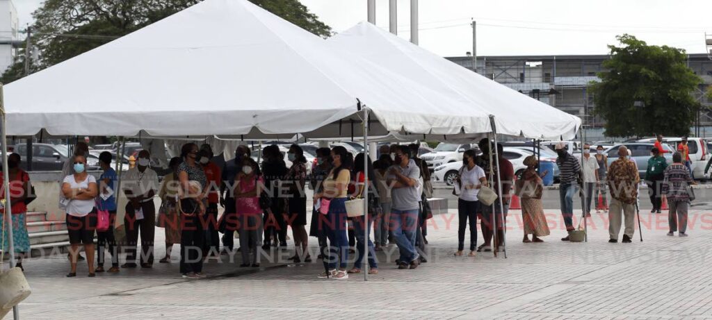 People wait to be registered for their booster shots at SAPA in San Fernando. - Lincoln Holder