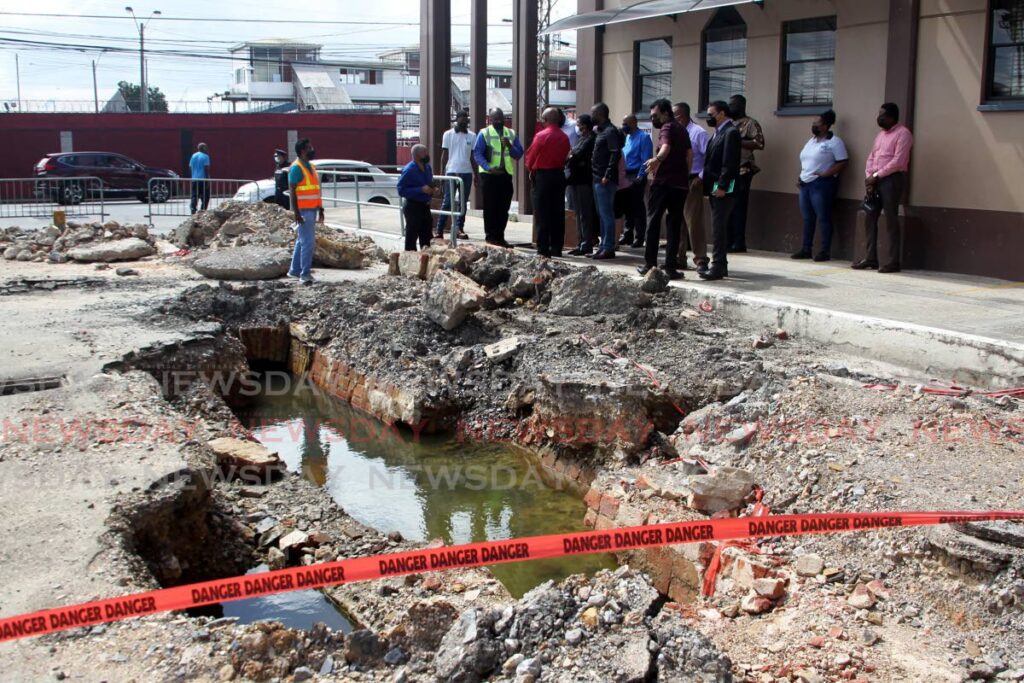 A team of government officials survey the site of lower George Street, Port of Spain which has been eroded by a collapsed underground drainage system on December 29, 2021. - PHOTO BY ROGER JACOB