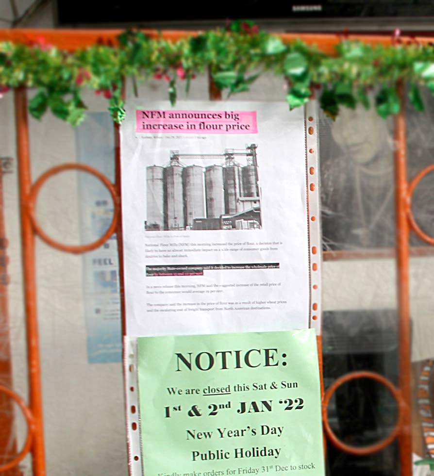 In this December 2021 photo, an article about the increase in the price of flour is placed on the glass at Chee Mooke Bakery to alert customers to a possible increase in the price of baked goods. Inflation is likely to be the biggest economic risk in 2022. - ROGER JACOB