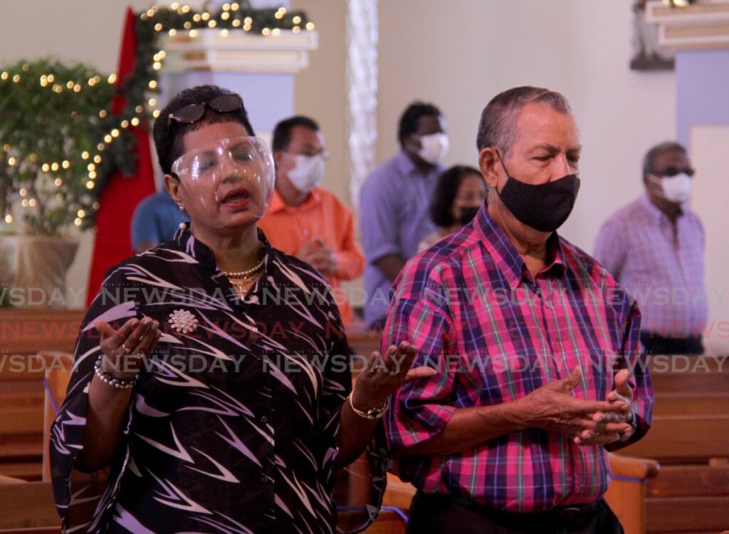 Parishioners pray during mass at Our Lady of Perpetual RC Church, San Fernando on New Year's Day. - PHOTO BY AYANNA KINSALE
