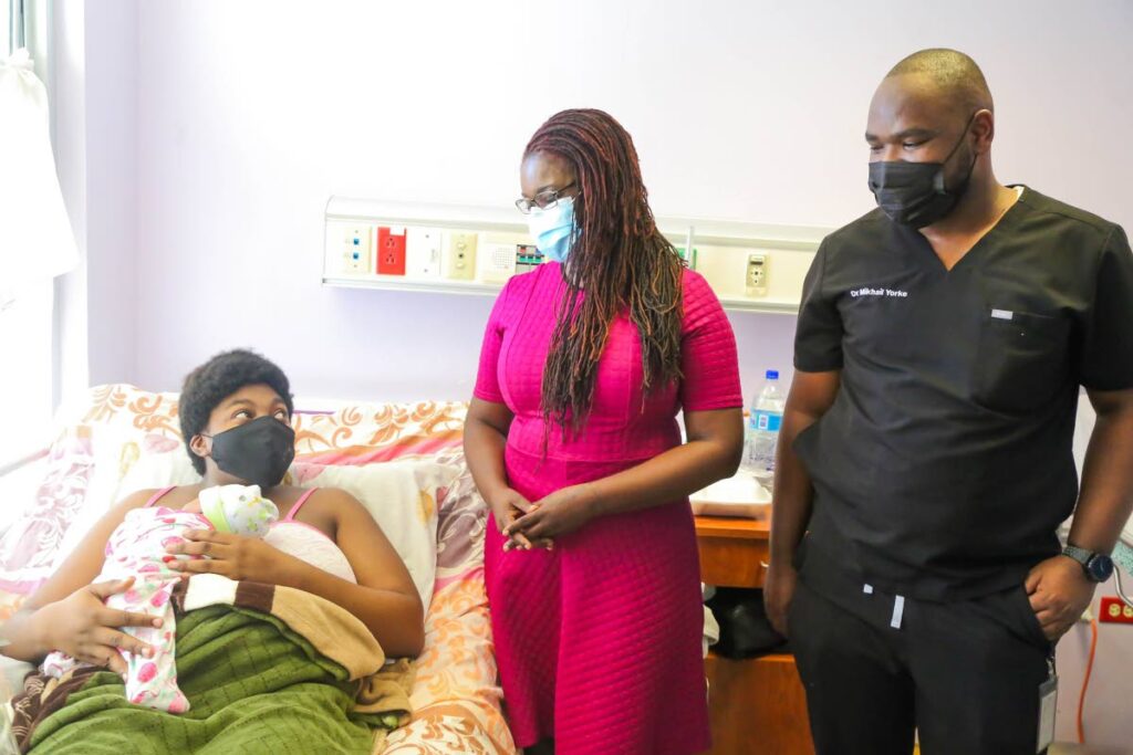  Dr Faith BYisrael, Secretary of Health, Wellness and Social Protection, chats with Celina Joseph who had a girl, Tobago's first birth on New Year's Day at Scarborough General Hospital. Looking on is house officer Dr Mikail Yorke. Photo courtesy the THA health division. - 