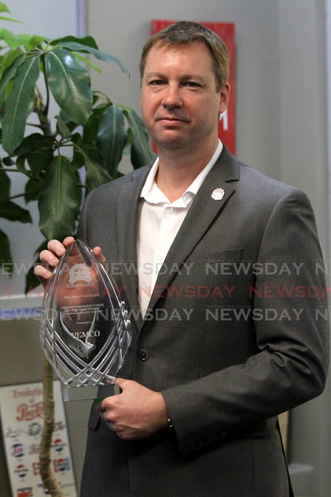 VEMCO CEO Christopher Alcazar holds the Premier Manufacturer of the Year Award, presented to the company by the Supermarket Association. - PHOTO BY ANGELO MARCELLE