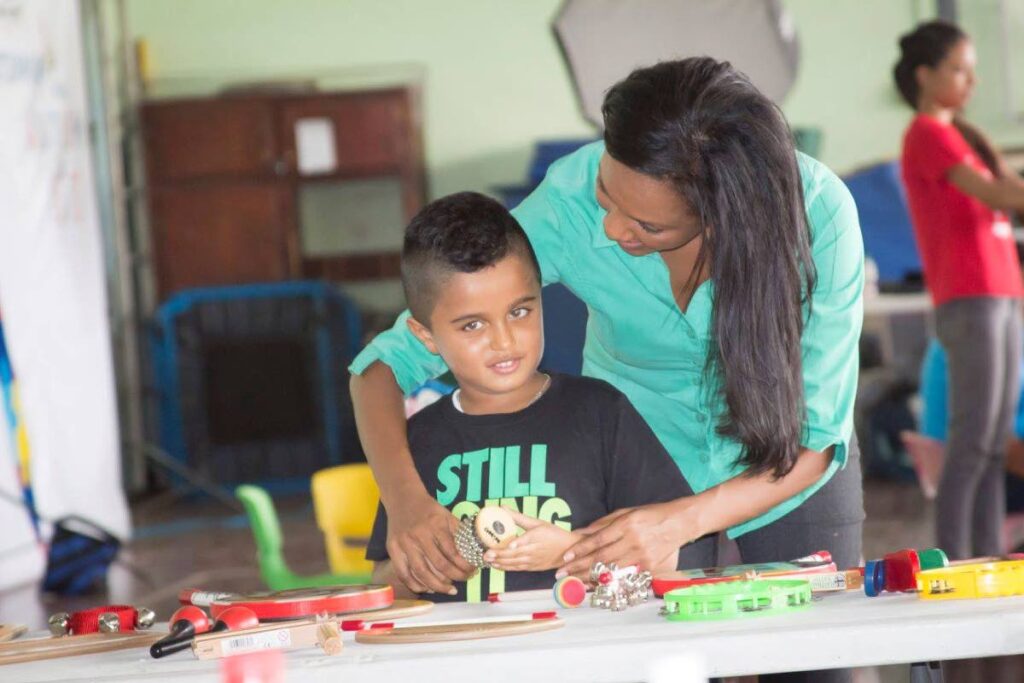Mitzy Sandy doing hands-on activity with a child. - courtesy Keegan Callender