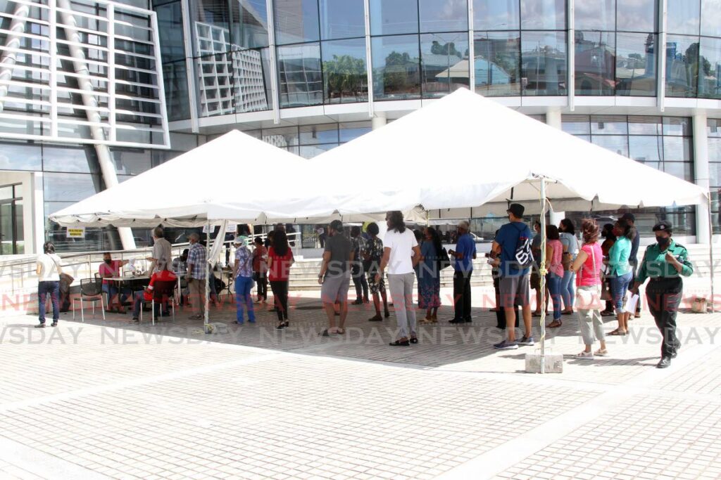 People wait for their turn to get the covid19 vaccine at the Southern Academy for the Performing Arts in San Fernando on Saturday. - Photo by Lincoln Holder