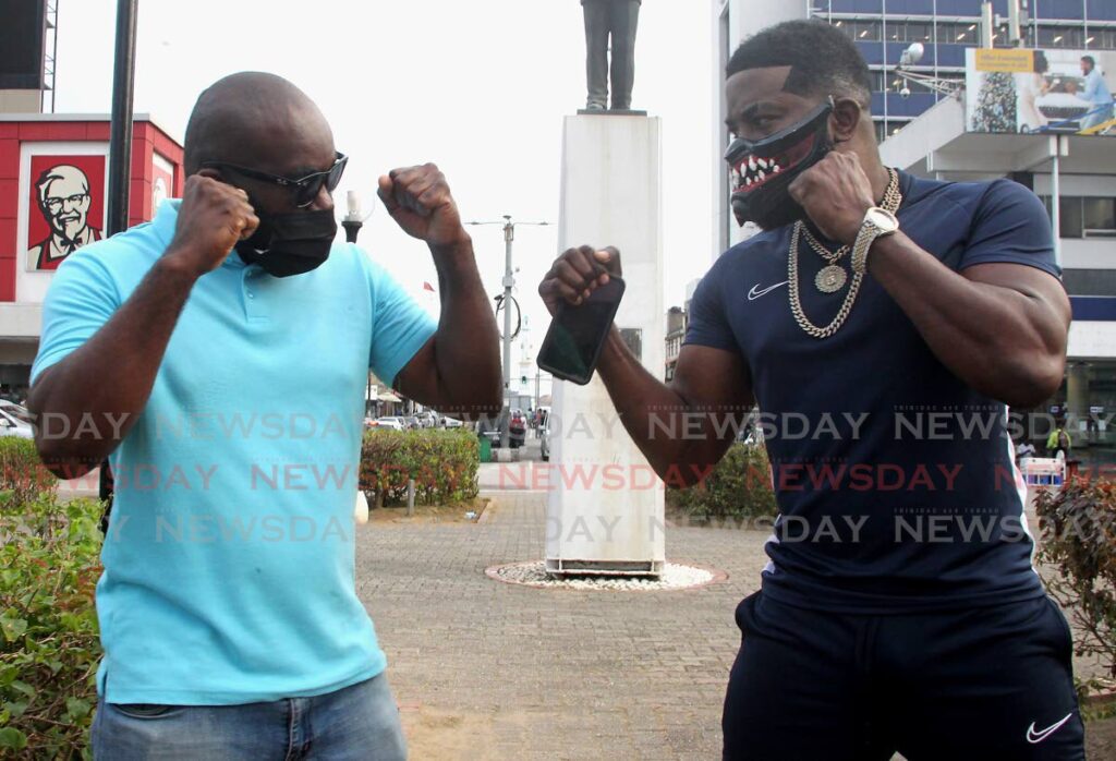 Soca artiste Swappi (R) faces off with fellow entertainer Squeezy Rankin ahead of their bout as part of the Sea Lots Boxing Community inititaive. Photo by Roger Jacob