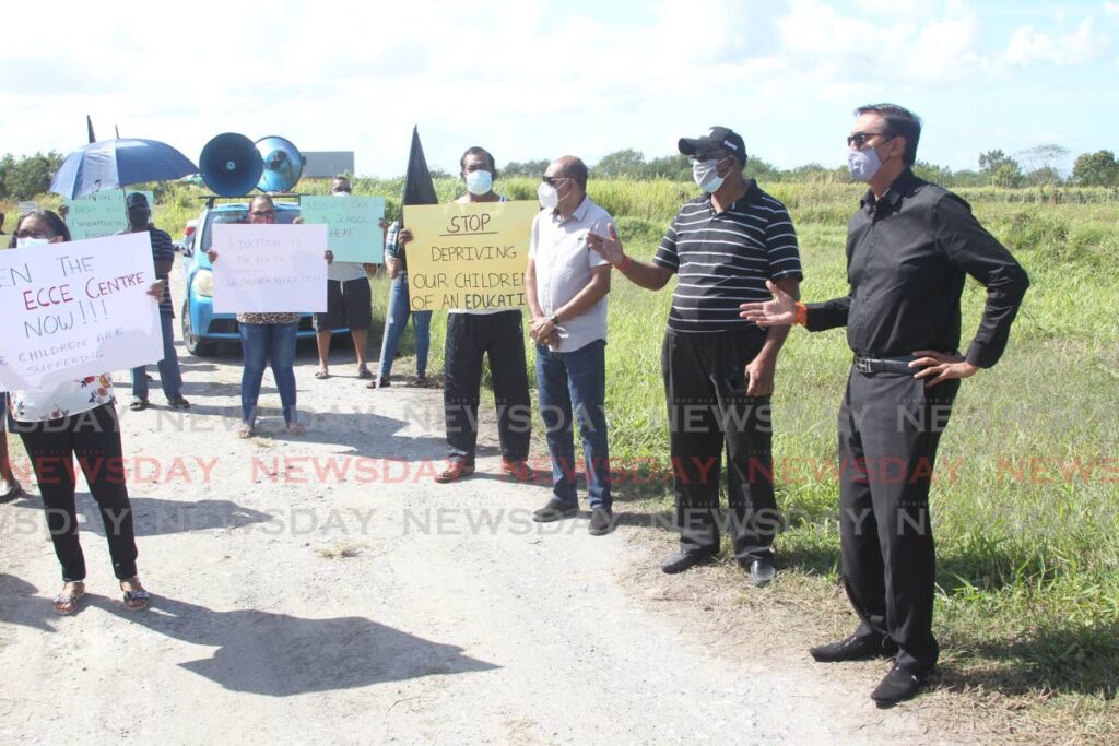 At right, Couva North MP Ravi Ratiram stand in solidarity with Waterloo residents to highlight their plight to have the Waterloo road, Carapichaima Early Childhood Care and Education centre opened. - Photo by Lincoln Holder