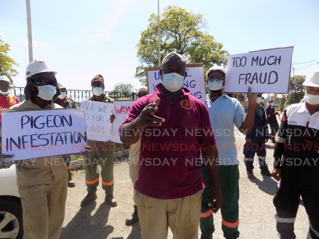 Worker for National Marine Maintenance Services Co Ltd Huewin Charles, second from right, speaks with Newsday during a protest at the Chaguaramas dock over poor working conditions and low wages on Thursday.  - Shane Superville