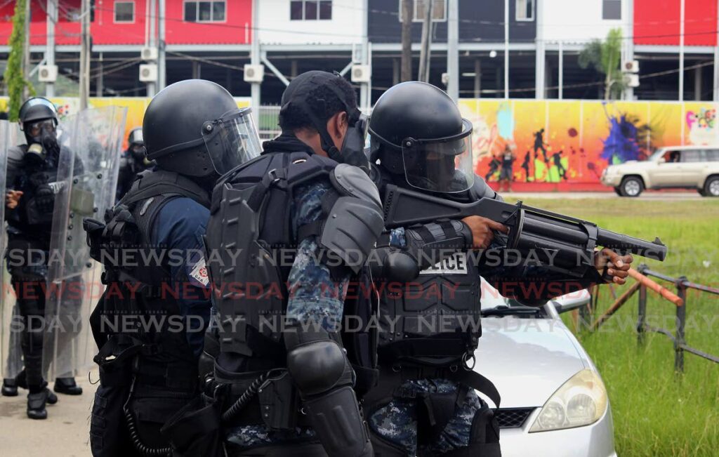 Police prepare to fire tear gas at the Queen's Park Savannah. Photo by Roger Jacob