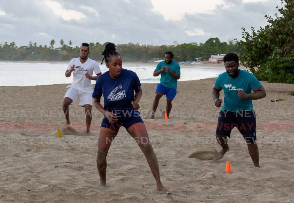 Dr Amelia Jacob, front, founder of No Excuses Fitness Club, leads a drill for members at Turtle Beach last Monday. - David Reid