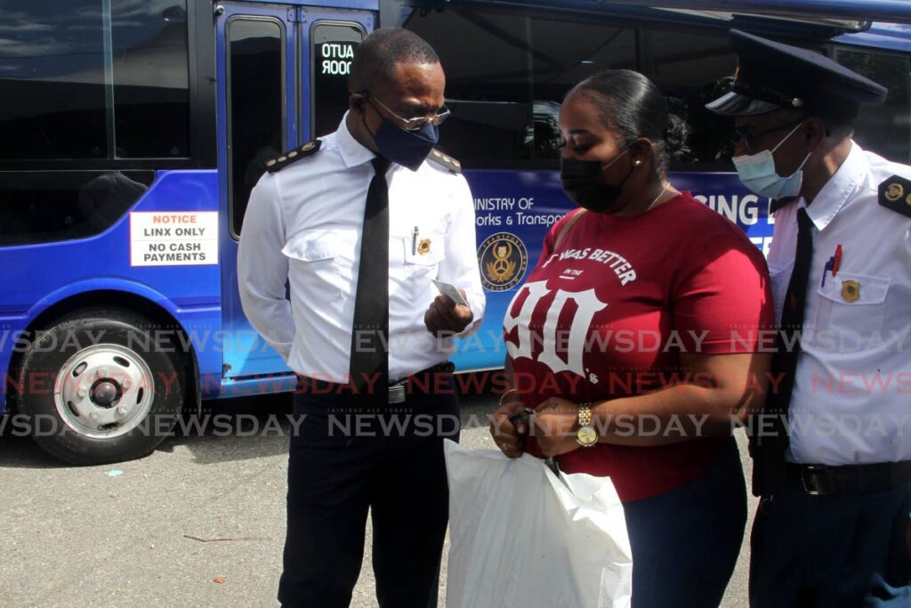 Transport Commissioner Clive Clarke, left, and ag Assistant Transport Commissioner Prakash Chaitram, chat with Everlee Boodoo after she received her new driver's permit from a newly operational mobile Licensing Division sub office as it visited Cumana, Toco, on Thursday. - ROGER JACOB