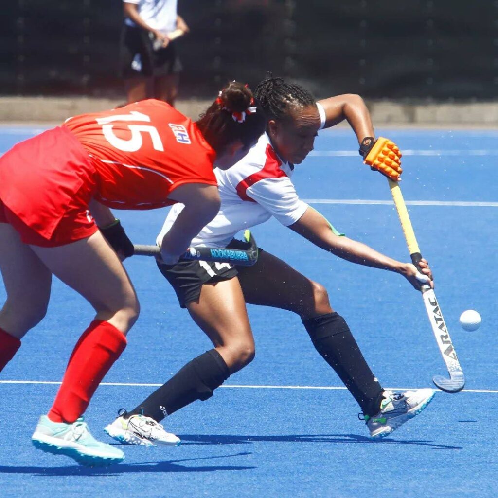 Trinidad and Tobago women's hockey player Zene Henry (right) moves with the ball while Peru's Victoria Montes looks on, during their 2022 Pan American Cup match in Santiago, Chile on Friday. PHOTO COURTESY PAN AM HOCKEY. - 