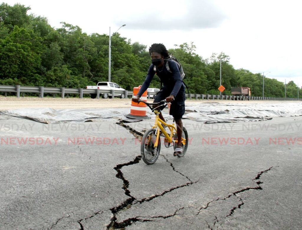 File photo: Alle Ali rides over the cracked surface of the South Trunk Road, Mosquito Creek, La Romaine construction zone in January. Photo by Ayanna Kinsale