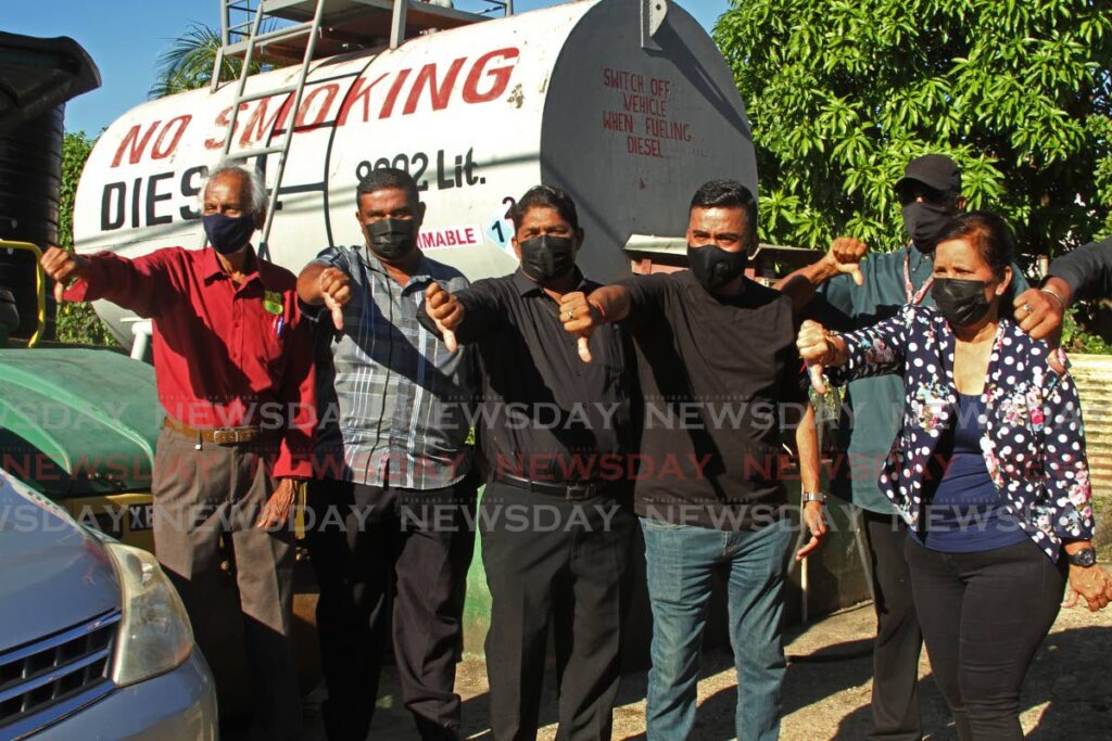 On Friday morning, the Penal/Debe Regional Coporation welcomed the press to an early morning demonstration.  Chairman Allan Sammy and MP for Oropouche West, Davendranath Tancoo, among other members of the coporation turn their thumbs down for disapproval.  - Photo by Marvin Hamilton