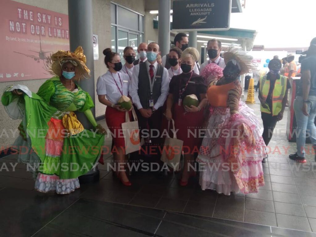 Two Dame Lorraines pose with the Virgin Atlantic crew outside of the ANR Robinson Airport, in Tobago on Saturday.  - Photo by Corey Connelly 