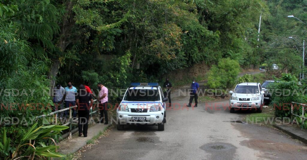 POLICE WORK: Police search for clues into the discovery of the dead body of Yannick Shaquille Warren in a ravine on Fondes Amandes Road, St Ann's, on Sunday. - Angelo Marcelle