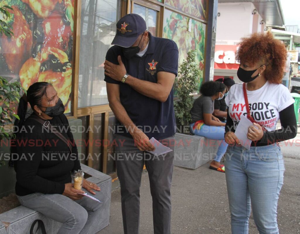 JTUM leader Ancel Roget speaks with a member of the public while Trisha Hamilton, leader of the My Body, My Choice movement looks on at the Siparia market on Monday. - AYANNA KINSALE