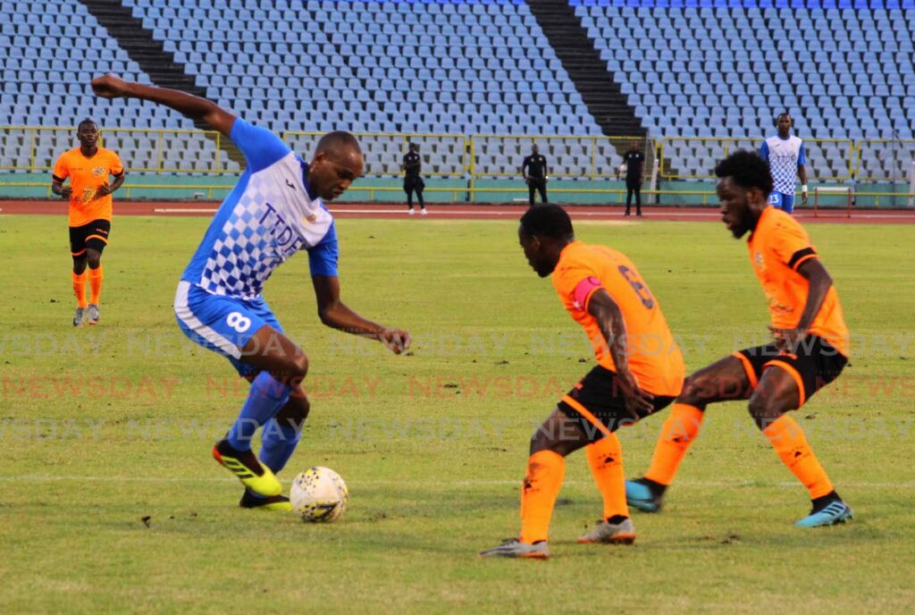 sports Defence Force striker Brent Sam takes on two Tiger Tanks Club Sando players in a Pro League match at the Hasely Crawford Stadium, Mucurapo. FILE PHOTO - 