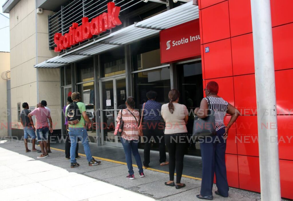 In this file photo, customers wait to use the ATM at the Scotiabank branch on the corner of Park and Pembroke Streets, Port of Spain. - 
