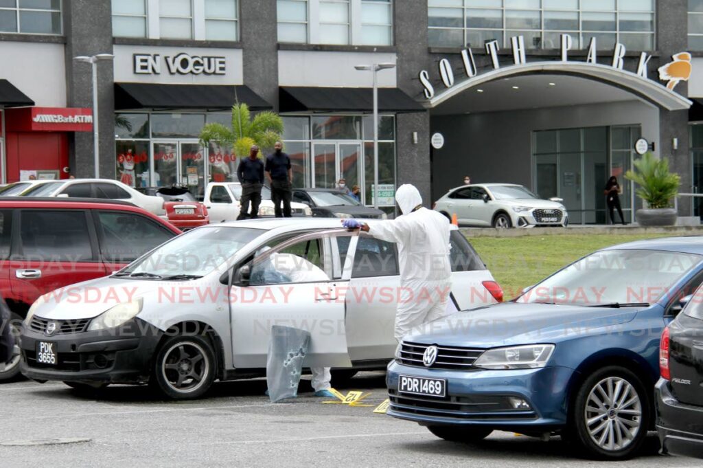 Crime scene investigators examine the car where two men were shot dead in the carpark at South Park mall, San Fernando on January 27. - AYANNA KINSALE