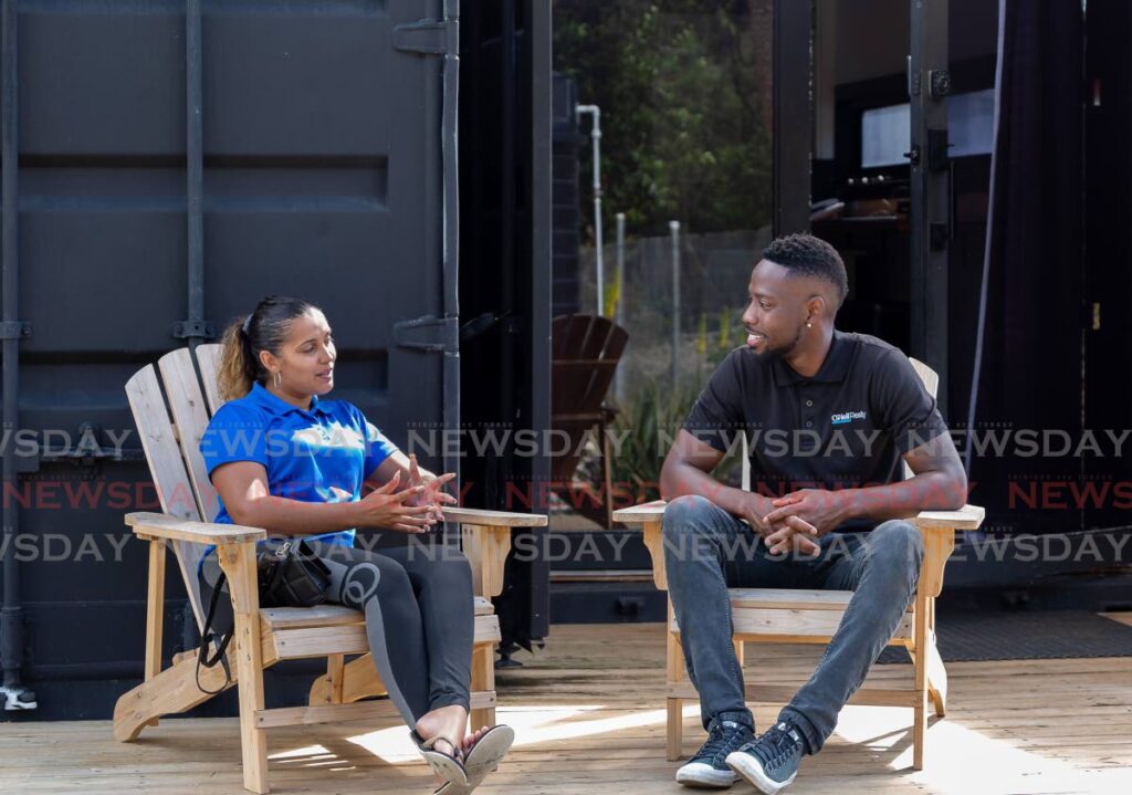 Keilon George and his fiancée Catherine Williamson chat outside their container home in Crown Point.  - David Reid