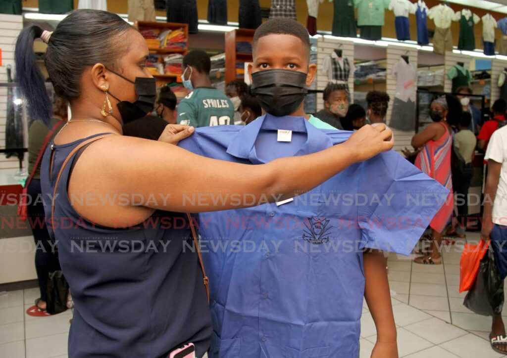 Ria Watson measures her son Rashawn for a shirt at Bradford Mall, Port of Spain, on Saturday, to wear on his first day of in-person classses as a form one student at Tranquility Government Secondary on Monday. - AYANNA KINSALE