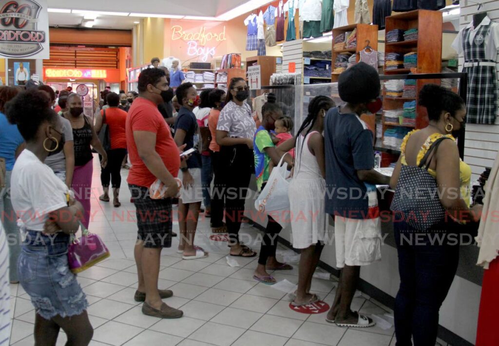 Parents and guardians shop for school uniforms at Bradford Mall, Port of Spain on Saturday as more children returned to physical classes on Monday. The Central Bank  in its January bulletin forecasts growth once there are no new pandemic lockdowns this year. - AYANNA KINSALE