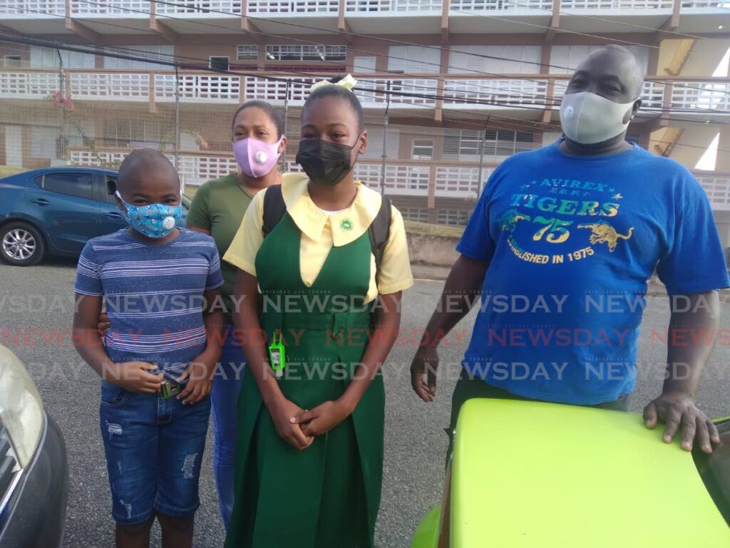 Signal Hill Secondary form one student Linell Covey arrives at school for the first time on Monday accompanied by her brother Lindell, mother Stacey Edwards and father Linwood Covey. - Photo by Corey Connelly