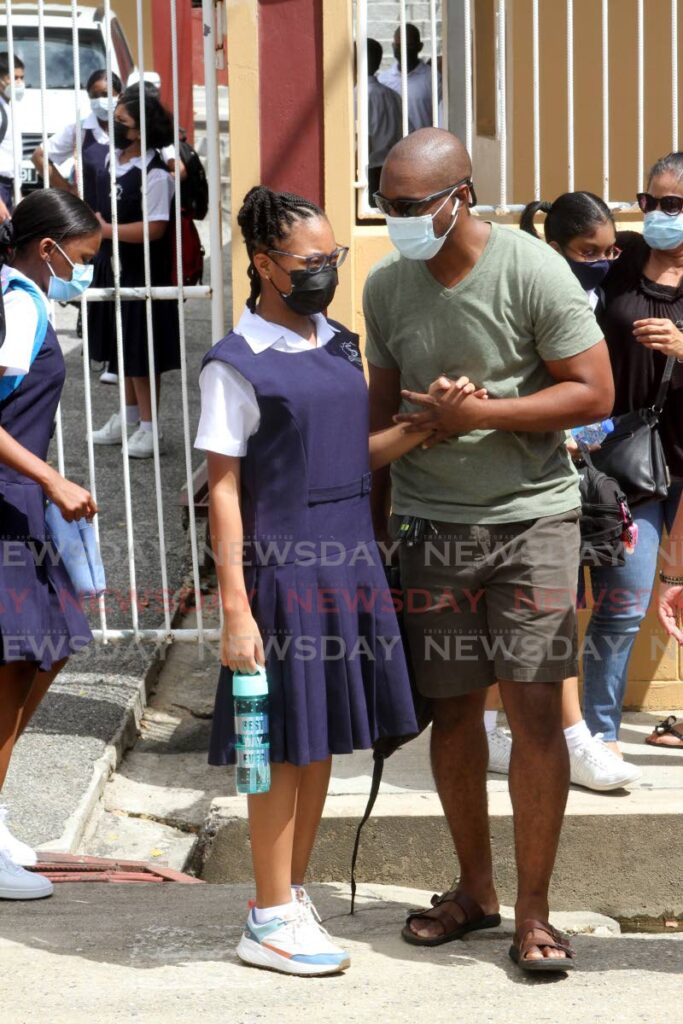 Specialist Learning Centre standard five student Anaya Young is received by her father after her first day of in-person classes at the school on Wilson Road, St Augustine on Monday. - Angelo Marcelle