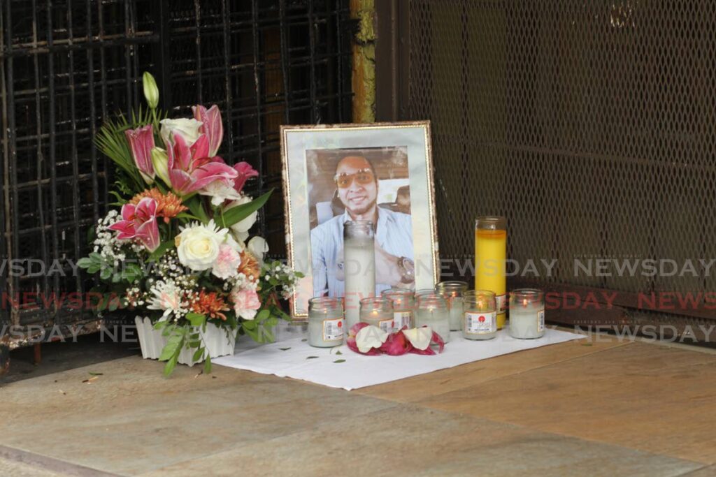 Flowers and candles were placed with a picture of Andy Alberto Macias Hosien, on the pavement in front of Ketan Jewellers on Tuesday. - Marvin Hamilton