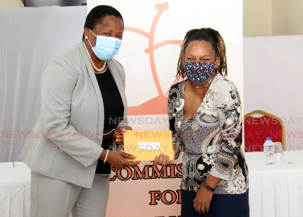 Member of Parliament for Arima Pennelope Beckles shares a laugh with recipient Katrina Lendore from Heights of Aripo as she receives a grant from the National Self Help Commission during a distribution ceremony at the MP's Constituency Office on Guanapo Road, Arima, Friday. - AYANNA KINSALE
