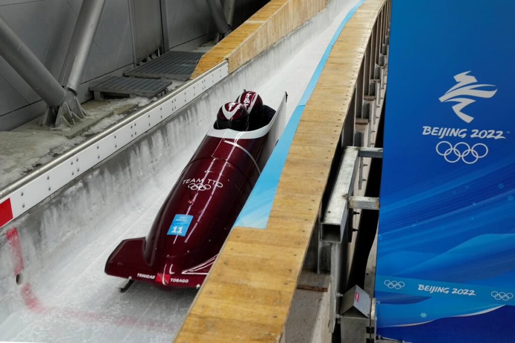 Axel Brown and Andre Marcano of Trinidad and Tobago speed down the track during a two-man bobsleigh training heat at the 2022 Winter Olympics, on Saturday, in the Yanqing district of Beijing. (AP Photo) - 
